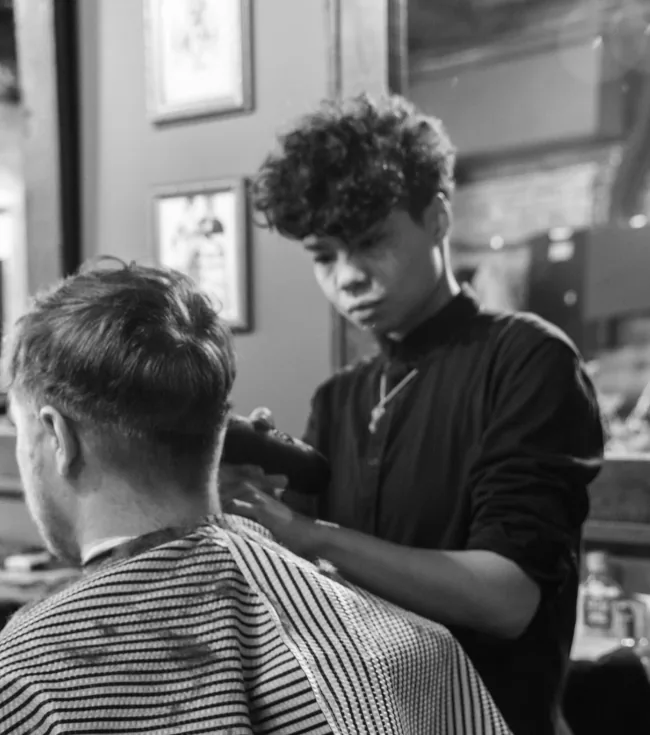 Close-up of a barber working on a client's fade